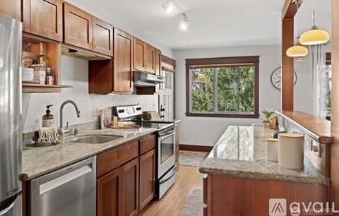 A kitchen with wooden cabinets and granite countertops.