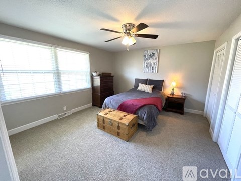A bedroom with a bed, dresser, and window.