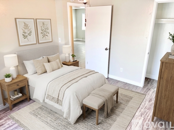 A bedroom with a large bed and a wooden nightstand.