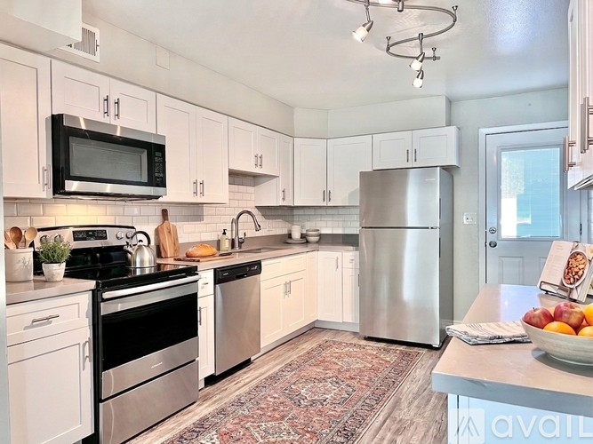 A kitchen with white cabinets and stainless steel appliances.