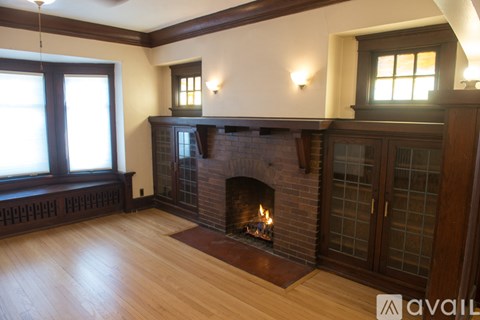 A living room with a fireplace and wooden floors.