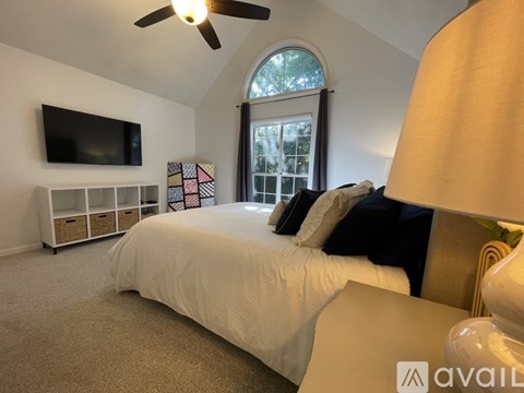 A bedroom with a large bed and a flat screen TV mounted on the wall.