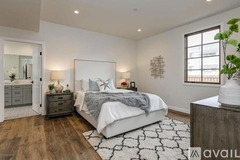 A bedroom with a large bed, a dresser, and a mirror.