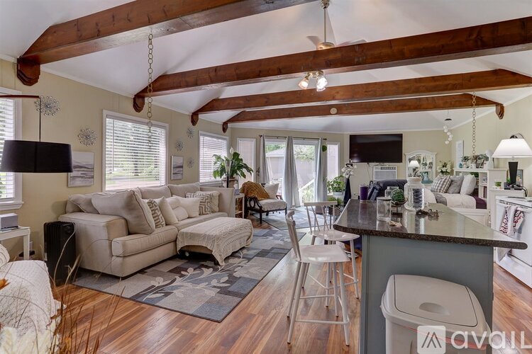 A living room with a couch, a chair, and a bar area.