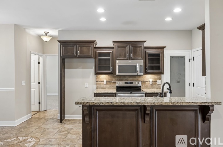 A kitchen with brown cabinets and a granite countertop.