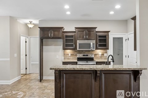 A kitchen with brown cabinets and a granite countertop.
