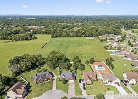 A bird's eye view of a suburban neighborhood with houses and a swimming pool.