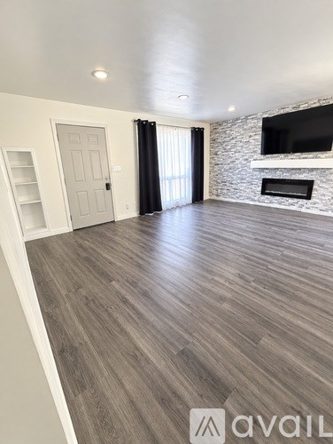 A spacious living room with a fireplace and a television.