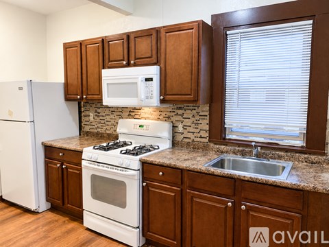 A kitchen with brown cabinets and a white fridge.