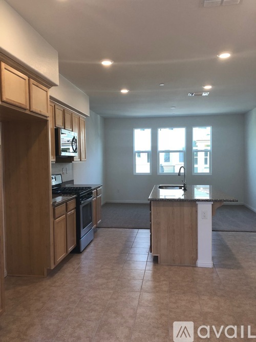 A kitchen with wooden cabinets and a tiled floor.