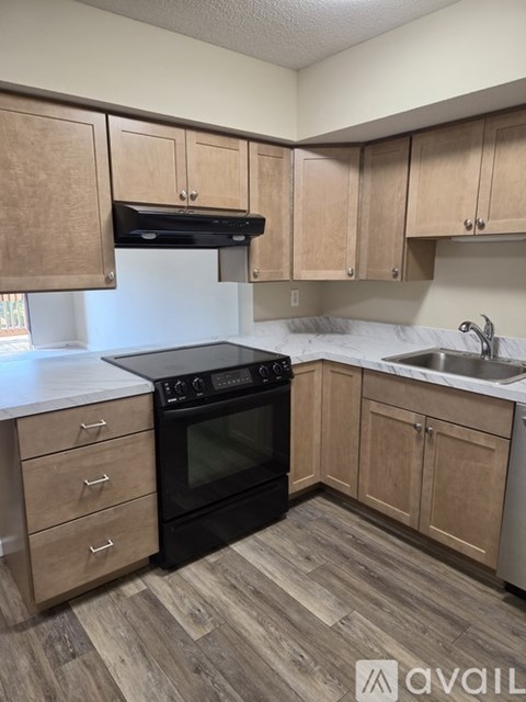 A kitchen with wooden cabinets and a black oven.