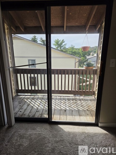 A balcony with a view of a house and trees.