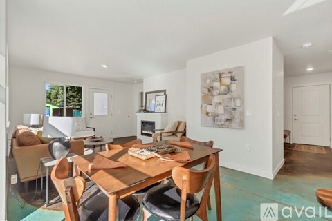 A dining room with a wooden table and chairs.