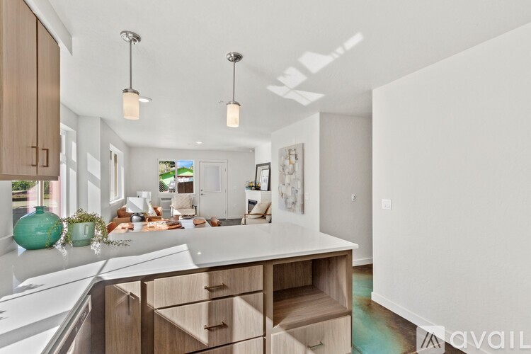 A kitchen with a white countertop and wooden cabinets.