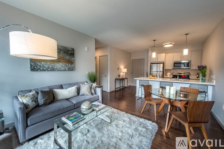 A living room with a grey couch and a glass coffee table.