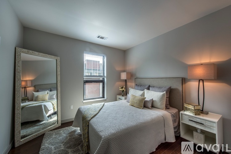 A bedroom with a large bed, a mirror, and a window.