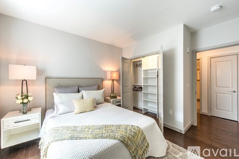 A bedroom with a bed, nightstand, and lamp.