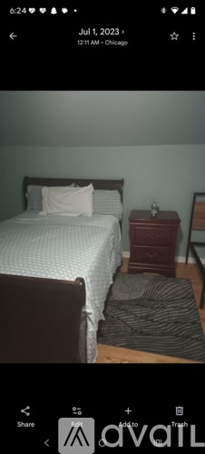 A bedroom with a bed, nightstand, and chair.