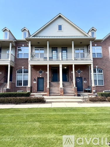 A two-story house with a front porch and a balcony.