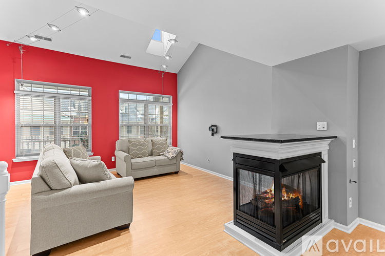A living room with a fireplace and two grey couches.