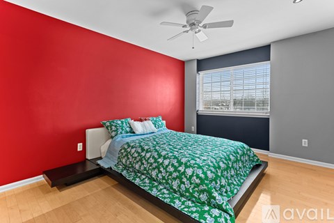 A bedroom with a bed, a ceiling fan, and a window with blinds.