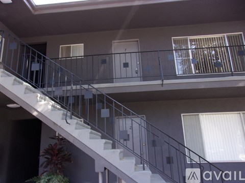 A staircase with a metal railing and a sign that says "available" on the wall.