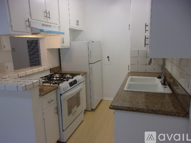 A kitchen with white appliances and cabinets.
