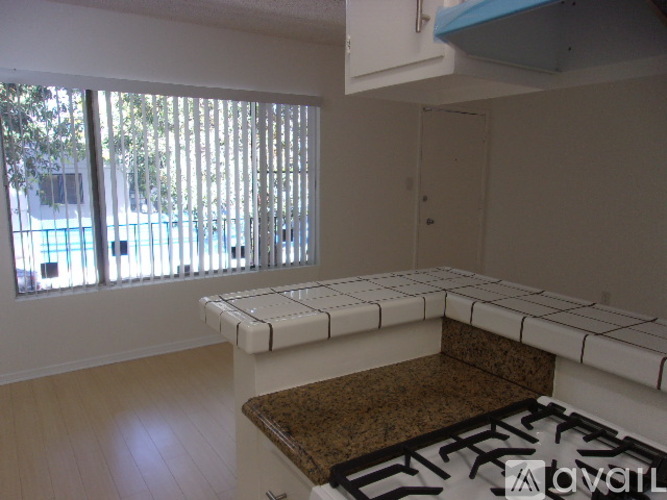 A kitchen with a brown counter and white cabinets.