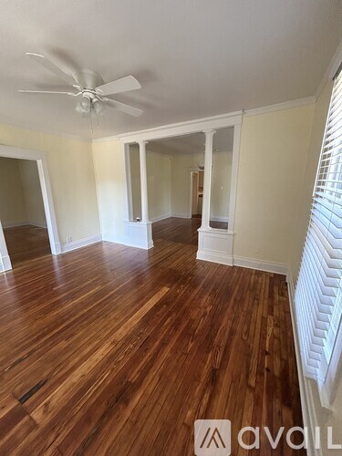 A room with wooden floors and a ceiling fan.