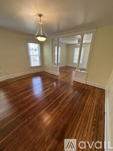 A room with wooden floors and a chandelier.