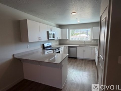 A kitchen with white cabinets and a white counter top.
