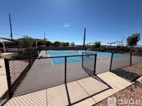 A pool surrounded by a black fence and a mesh screen.