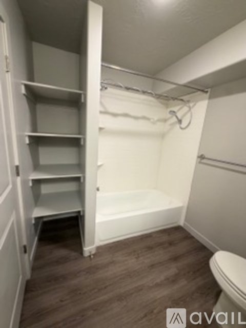 A small bathroom with a toilet, a bathtub, and a walk-in shower.