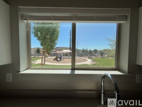A window with a view of a park and a playground.