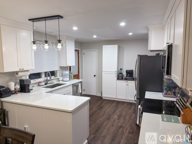A kitchen with white cabinets and a black fridge.