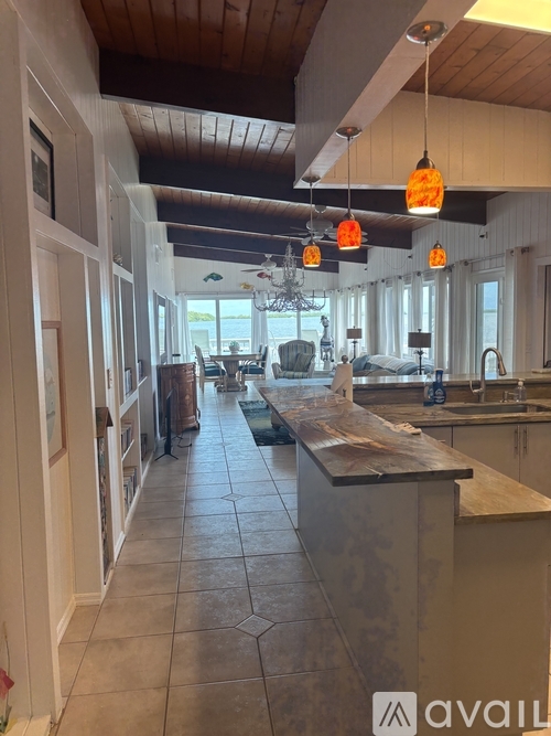 A kitchen with a long island in the middle.