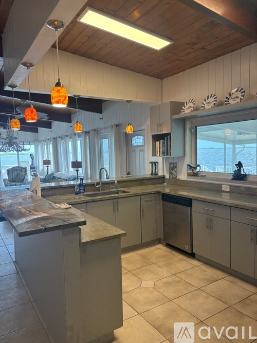 A kitchen with a wooden ceiling and a large island in the middle.