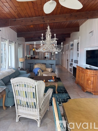 A living room with a white chair and a chandelier.