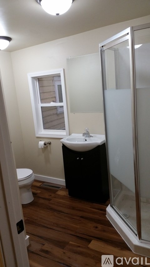 A bathroom with a toilet, sink, and shower.