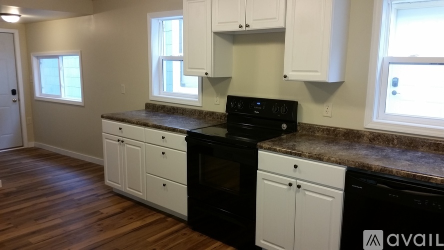 A kitchen with white cabinets and a black stove top oven.
