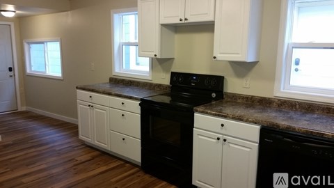 A kitchen with white cabinets and a black stove top oven.