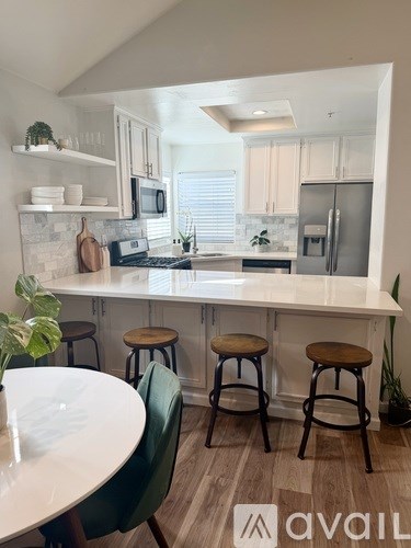 A kitchen with a white countertop and green chairs.