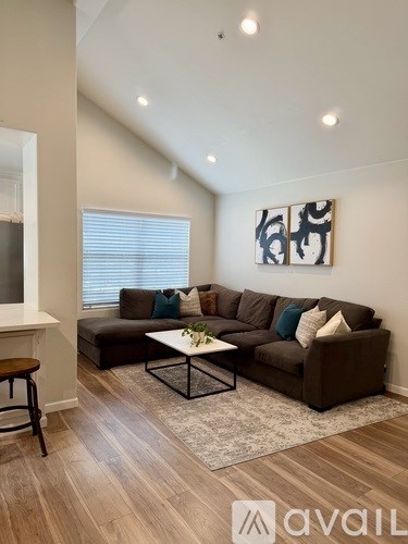 A living room with a brown couch and a coffee table.