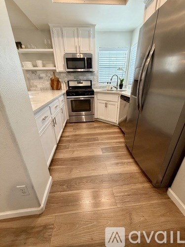 A kitchen with a refrigerator on the right side.