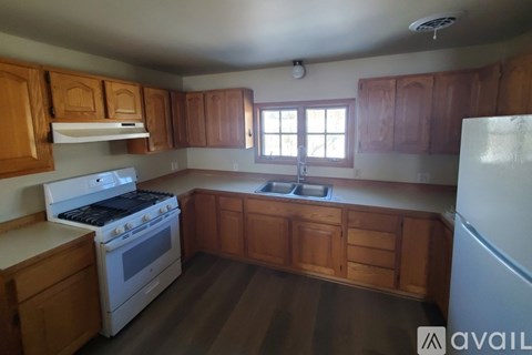 A kitchen with wooden cabinets and a white stove top oven.