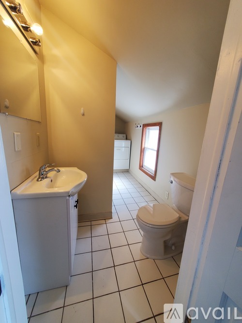 A bathroom with a toilet, sink, and mirror.