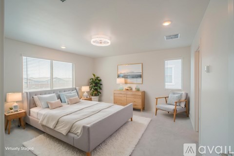 A bedroom with a large bed, a chair, and a painting on the wall.