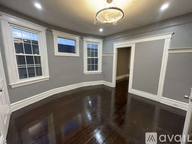 A room with wooden floors and white trimmed windows and doors.