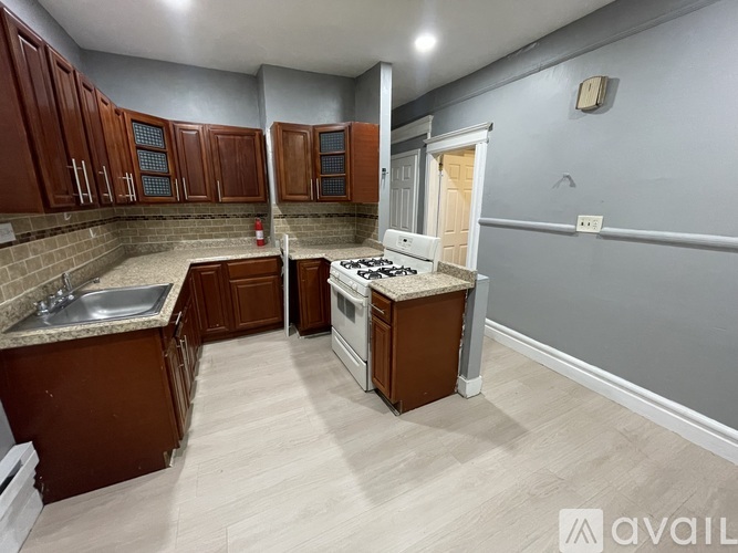 A kitchen with wooden cabinets and a white stove top oven.