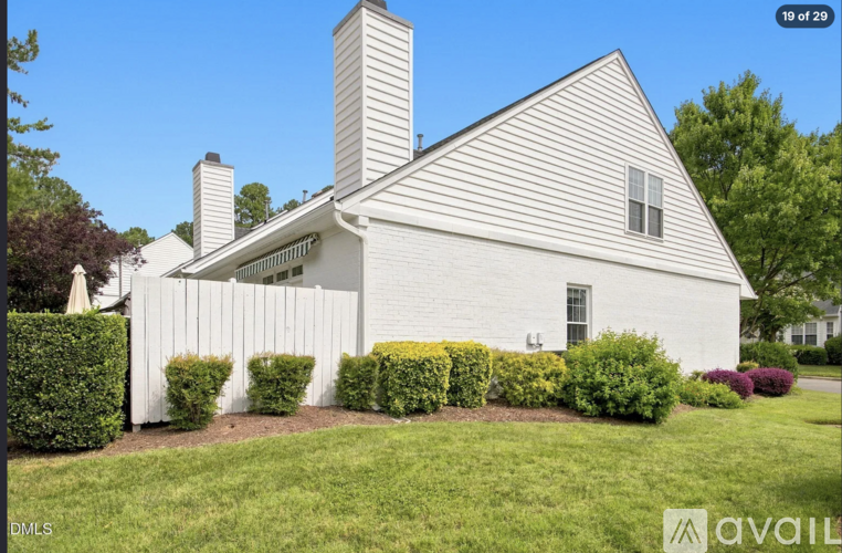 A white house with a chimney and a window.